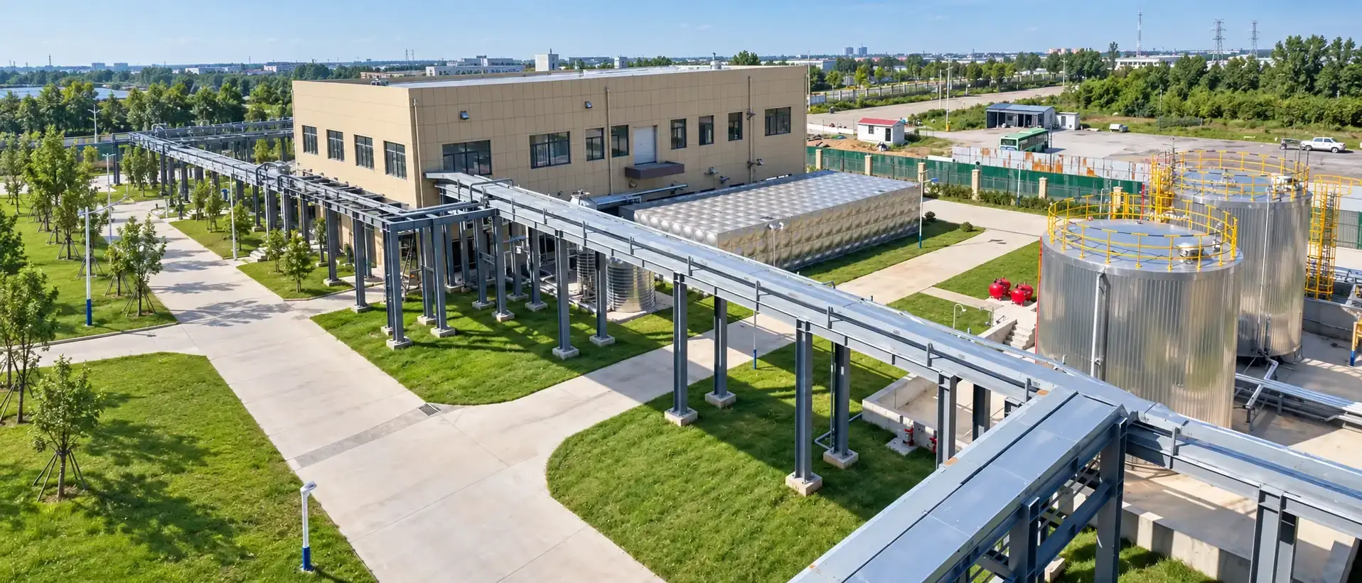 Aerial view of the plant: pipe racks running between bulk storage tanks and the production building