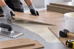 Vinyl flooring and carpet tile laid into a trowelled bed of water-based adhesive