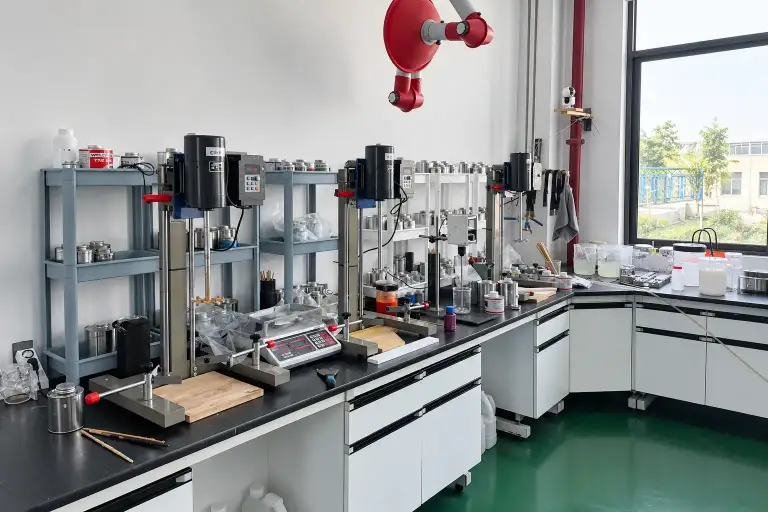 Quality control bench with laboratory stirrers, a weighing scale, sample tins and prepared wooden test panels
