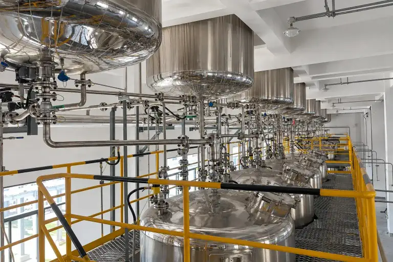 Stainless steel process pipework and valve manifolds connecting vessels on an upper platform of the plant